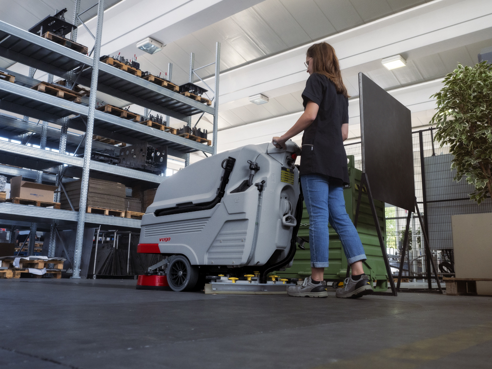 Pulizia del pavimento industriale in cemento con la lavasciuga pavimenti uomo a terra Comac Vega